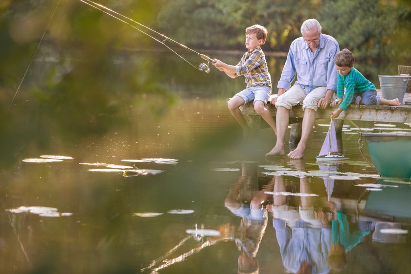 Großvater spielt mit Kindern am See