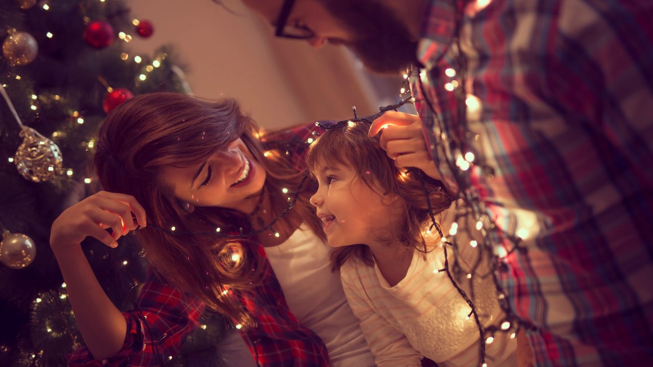 Familienfotos Weihnachten: Familie im Happy-Weihnachts-Chaos vorm Christbaum