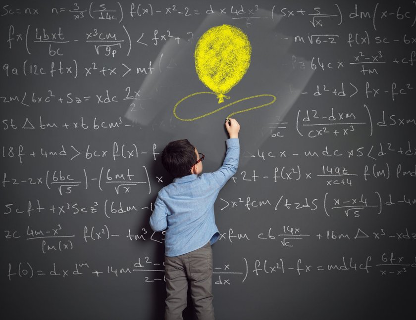 Von Kindern lernen: Kind steht an der Tafel und malt einen Ballon