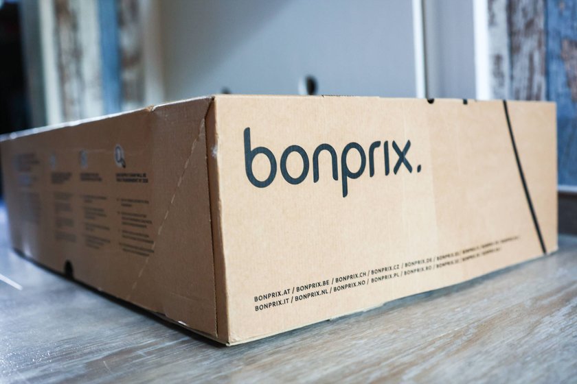 Ein Paket mit einem Bonprix Logo auf einer grauen Oberfläche
