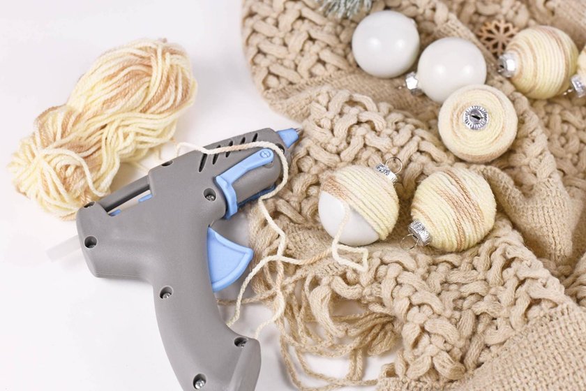 DIY-Kugeln im Boho-Stil mit cremefarbener Kordel, die mit einer Heiﬂklebepistole an Kugeln befestigt werden
