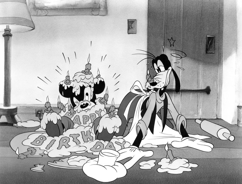 Goofy lässt eine Torte auf Mickey Mouse fallen