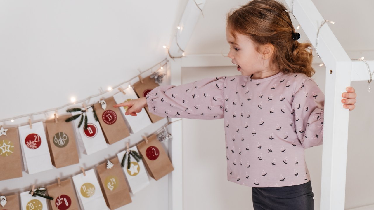 Montessori-Adventskalender: Kind mit Weihnachtskalender