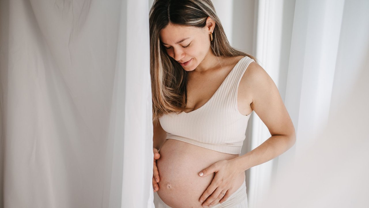 One woman, beautiful pregnant woman touching her belly.