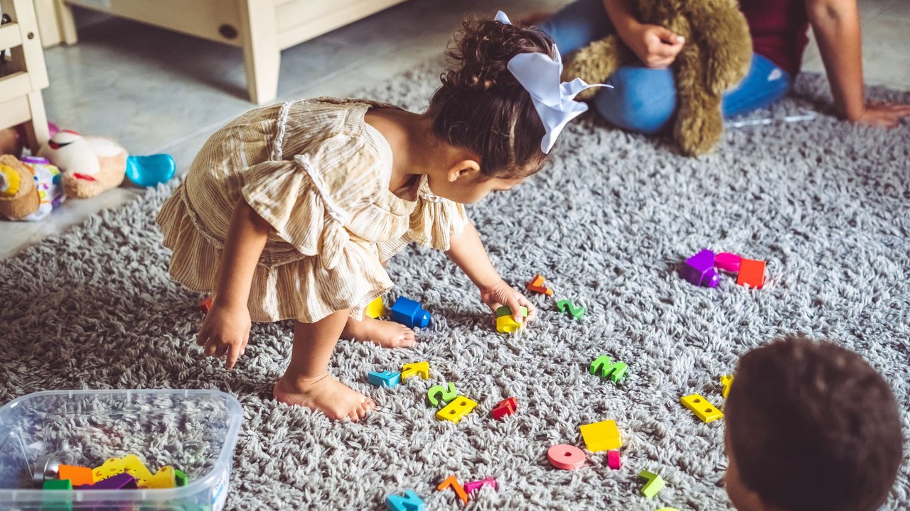 Kind räumt im Kinderzimmer auf