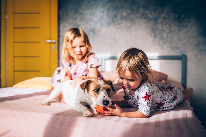 IMAGO Creative: Jahreszeit Winter, Fantasievoll drinnen spielen Sisters stroking dog in bedroom model released Symbolfoto property released OMIF00085