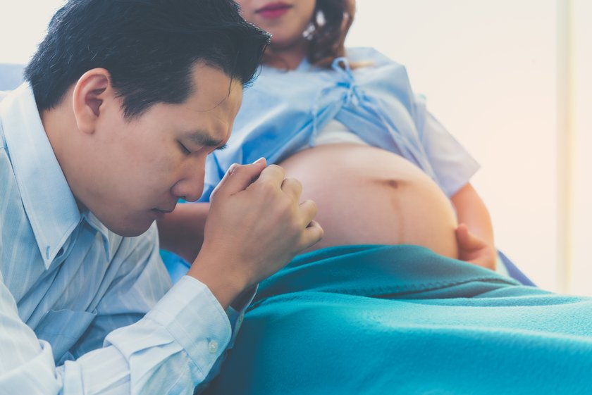 Besorgter Mann neben schwangerer Frau