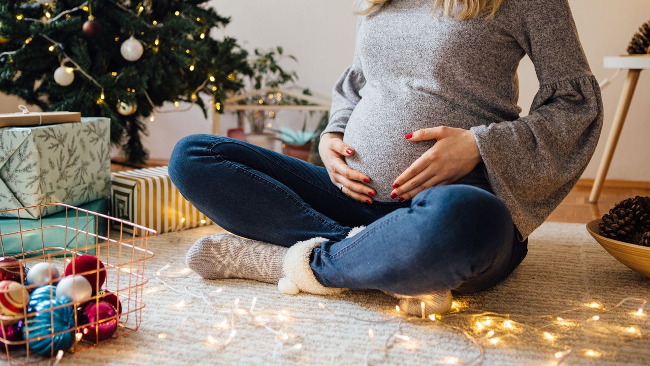 Adventskalender für Schwangere: Schwangere vor Weihnachtsbaum