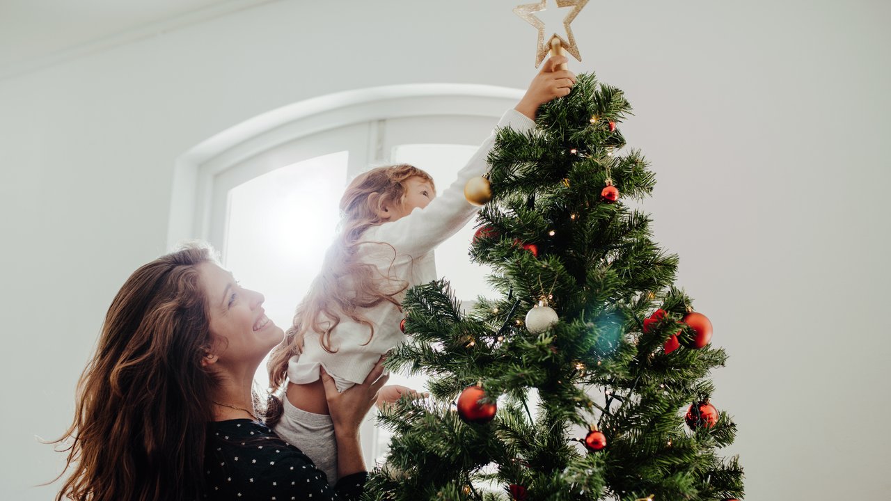 Mother and child decorating Christmas tree.