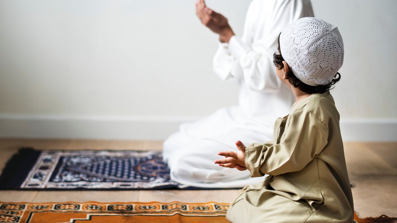 Was bedeutet Ramadan? Kleiner Junge betet zum Ramadan zusammen mit seinem Papa