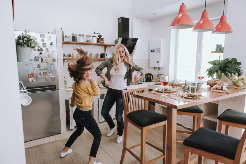 Mutter und Tochter tanzen in der Küche