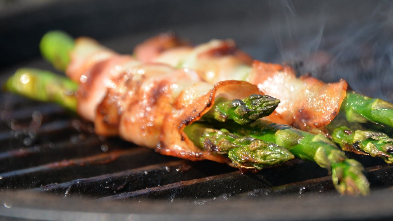 Spargel lässt sich auch auf dem Grill zubereiten, hier mit Speckstreifen umwickelt.