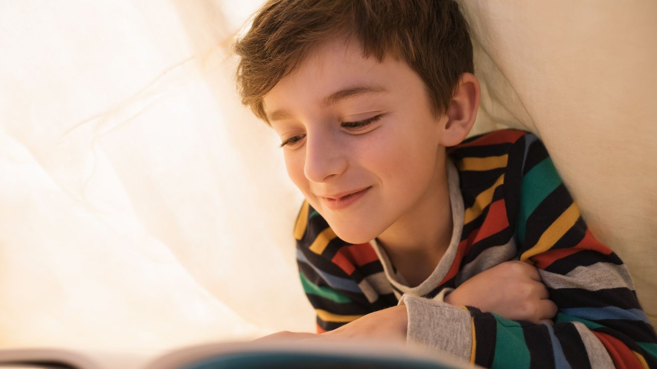 Glücklicher Junge liest ein Buch