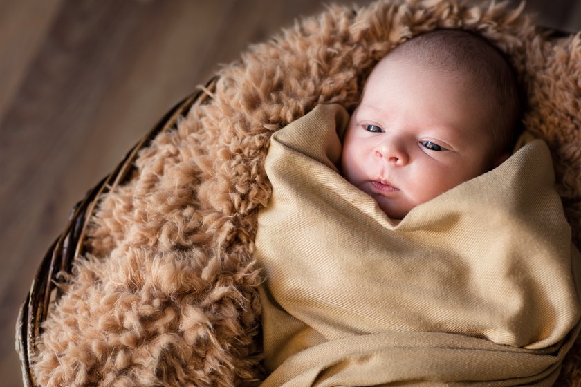 wrapped newborn lying in basket, newborn photography
