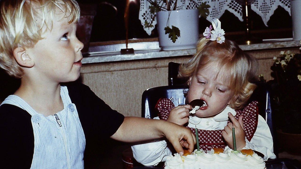Ein kleiner Junge und seine Schwester essen Torte in den 80er Jahren