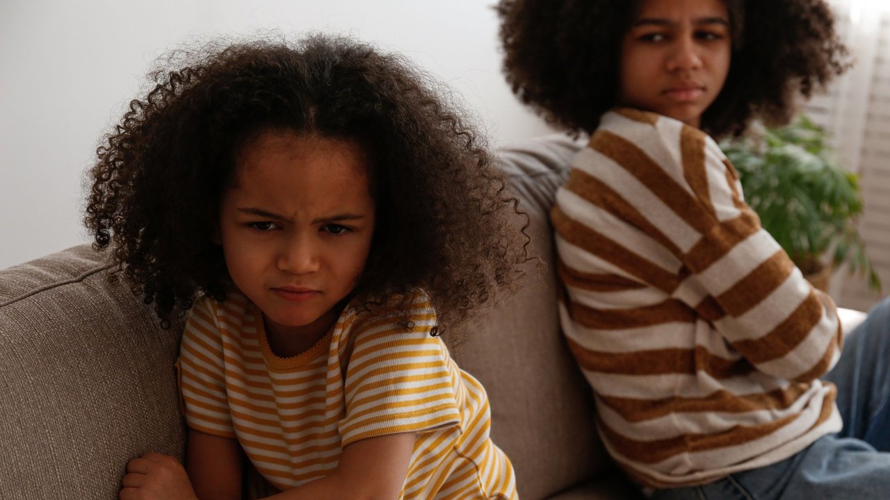 Kinder streiten: Zwei Kinder wütend auf Sofa