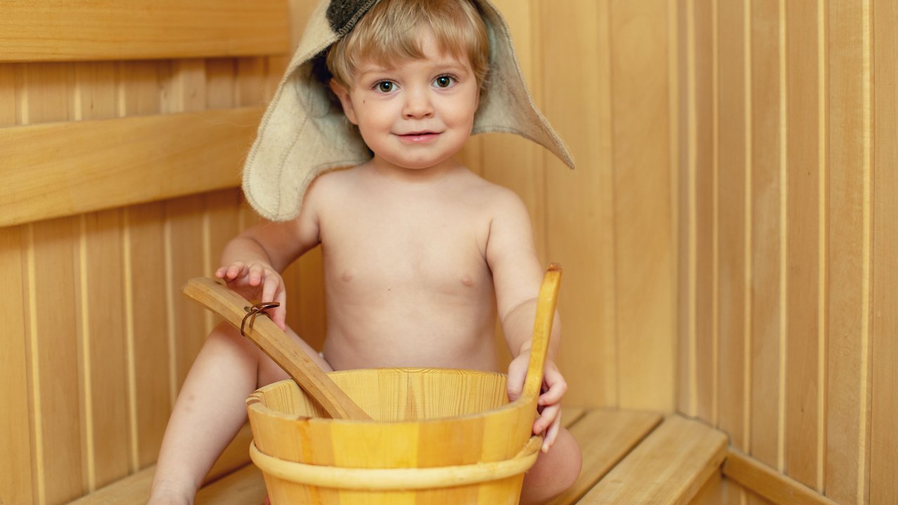 Beauty, healthcare. baby Boy relaxing in the sauna Toddler with broom and hat in russian sauna or bath