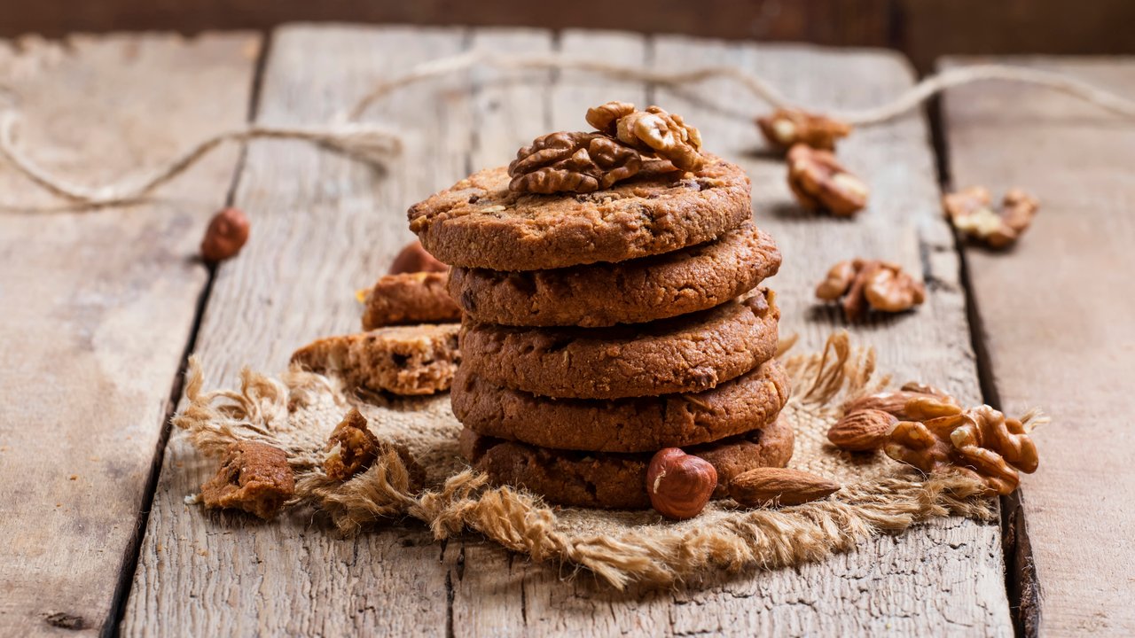 Chocolate cookies with nuts, vintage wooden background, selective focus