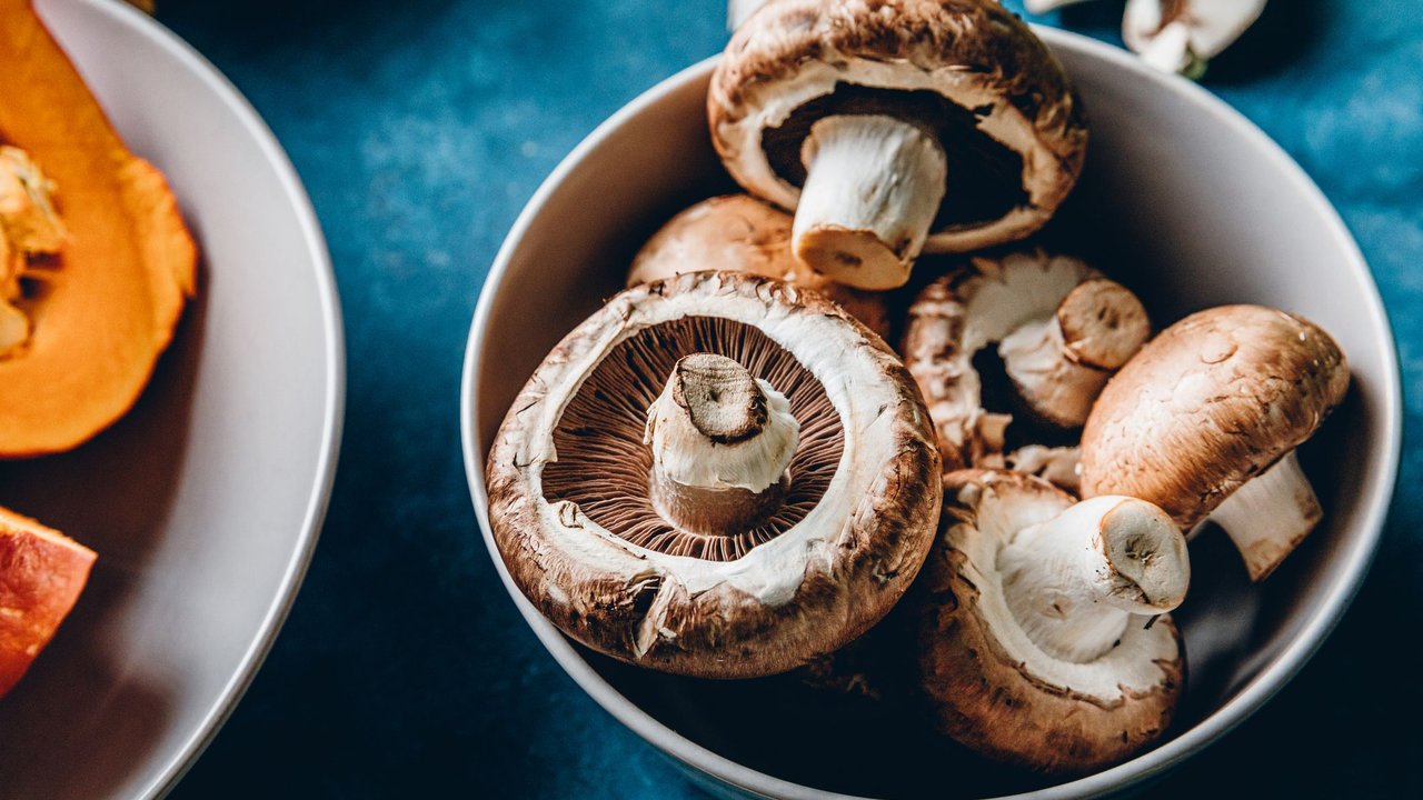 Eine Schale mit Pilzen steht auf einem Tisch