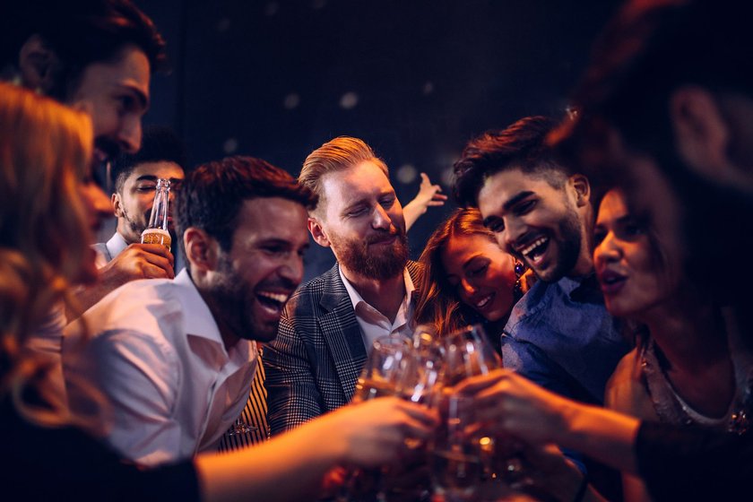 Lachende Freunde in einer vollen Bar