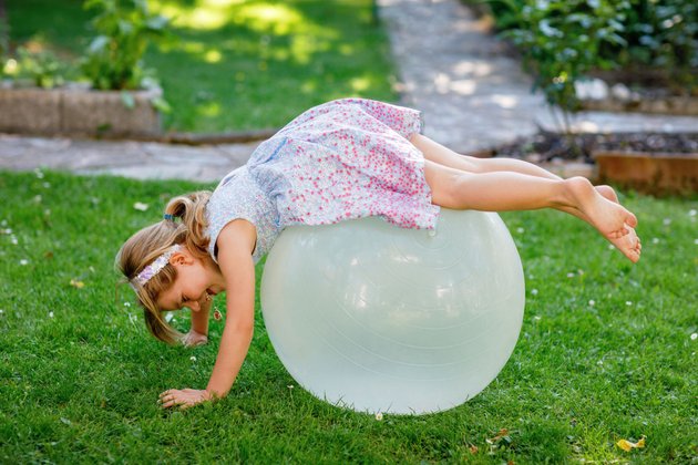 Zirkus-Geburtstag: Kind macht Akrobatik auf einem großen Ball
