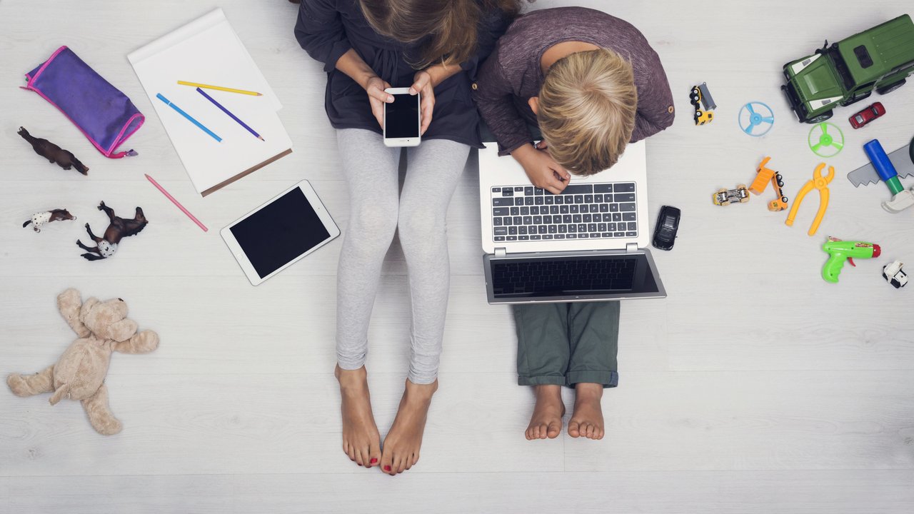 Kids using tablet, smartphone and laptop and neglecting normal toys. Spoiled generation model released