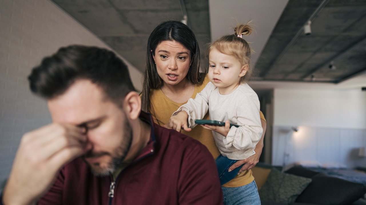 Passenger Parenting: Eltern diskutieren mit Kind auf dem Arm