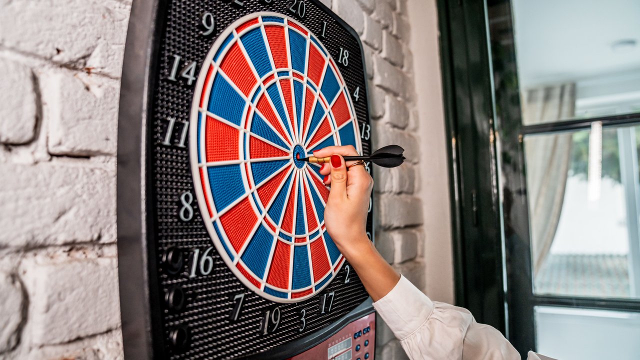 Frau spielt Dart mit elektronischer Dartscheibe