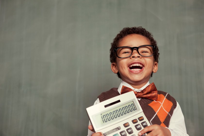 Mathe Witze: Junge mit Brille hält älteren Taschenrechner und lacht
